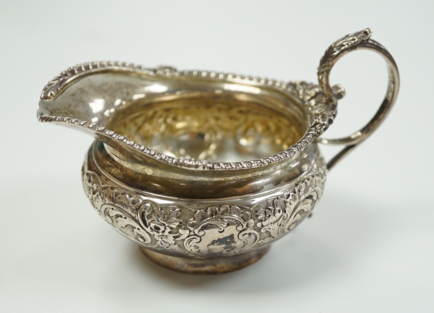 A late Victorian embossed squat silver cream jug, Edward Barnard & Sons, London, 1898, height 74mm, 4.6oz.